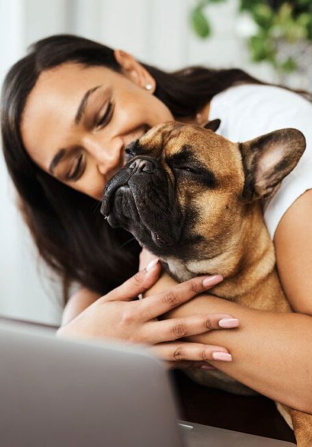 Pet Owner Hugging Dog In Front Of Laptop